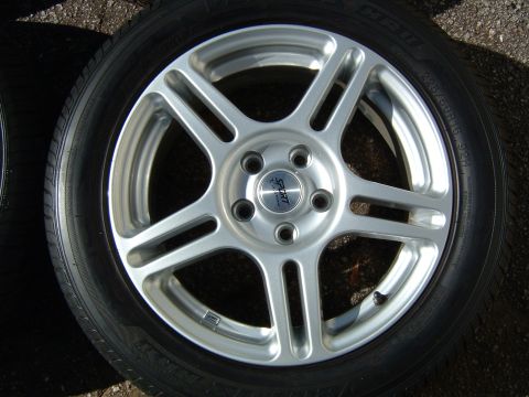 1997 Ford Taurus - A single silver 5-spoke wheel with a black tire is shown, a 'SPORT' branded center cap.