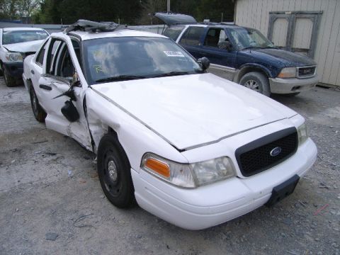 2003 Ford Crown Victoria - This damaged 2003 Ford Crown Victoria shows significant impact on the driver's side front quarter panel and door.