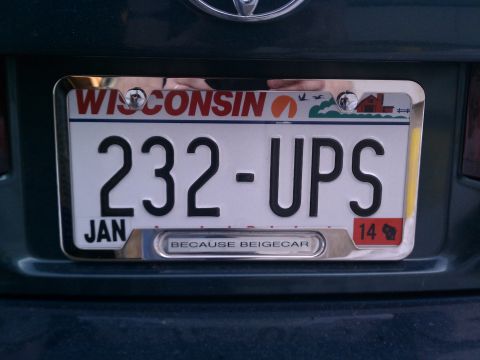 1998 Toyota Camry - The rear of a dark green vehicle displays a Wisconsin license plate with the number 232-UPS and a frame that reads "BECAUSE BEIGECAR".