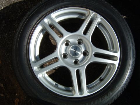 1997 Ford Taurus - A single silver alloy wheel with a sport center cap is shown, mounted on a tire.