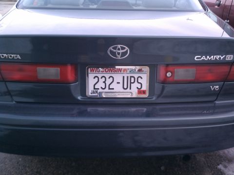 1998 Toyota Camry - The rear of a dark-colored Toyota Camry, showing the taillights and license plate.