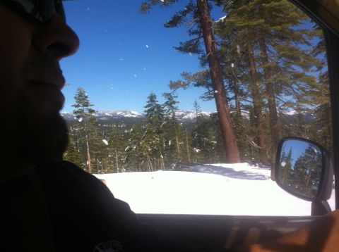 1989 Ford Bronco - Winter landscape viewed from inside a vehicle, showing snow-covered trees and distant mountains.