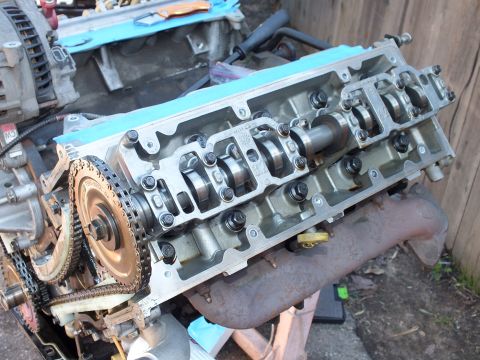 2003 Ford Crown Victoria - Close view of an aluminum cylinder head showing camshaft, valves and chain sprocket on a disassembled V6.