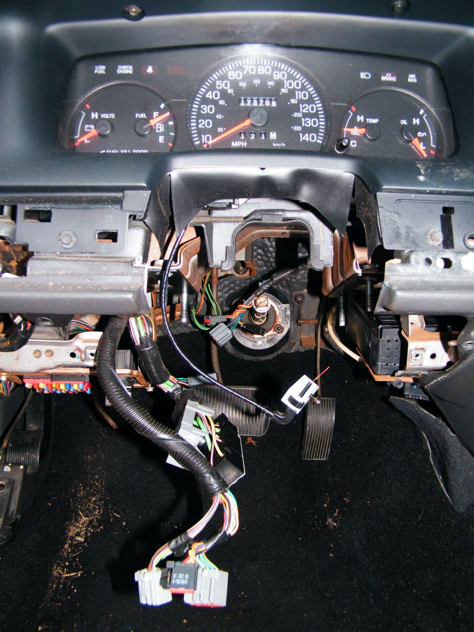 Dashboard wiring is exposed with steering column and pedals visible. Odometer shows 123788 miles
