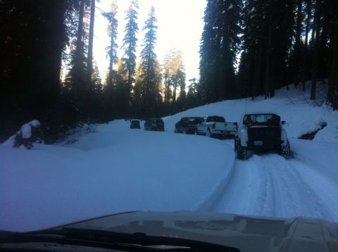 1989 Ford Bronco - Multiple vehicles navigate a snow-covered forest road.