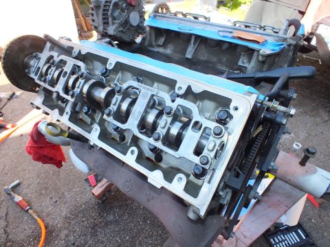 2003 Ford Crown Victoria - Three-quarter view of a freshly cleaned cylinder head with camshaft installed on a V6 in a driveway.