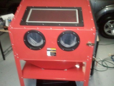 1994 Ford Bronco - A red sandblaster cabinet is shown in a workshop setting with a vehicle partially visible in the background.
