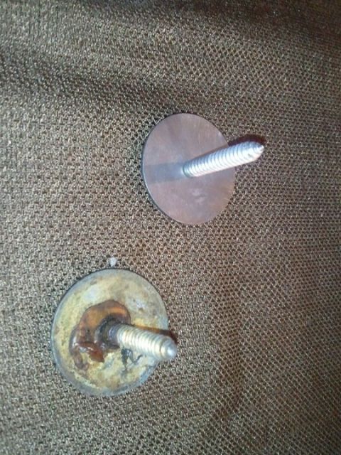 1994 Ford Bronco - Two metal mounting brackets with screws are shown against a textured background.
