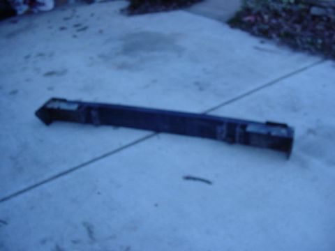 1992 Ford Bronco - A black bumper is shown on a concrete surface, with visible mounting points and some wear.