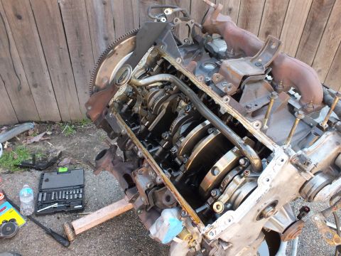 2003 Ford Crown Victoria - Engine block turned over to expose the crankshaft and main bearing caps during teardown