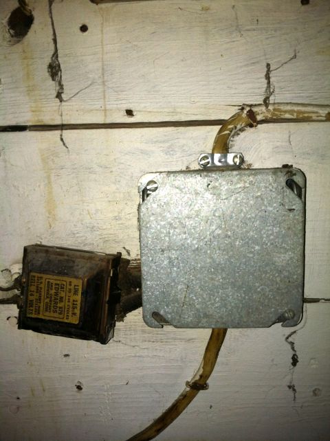 2005 Ford Crown Victoria - An electrical transformer and a junction box are mounted on a wooden wall, with visible wiring.