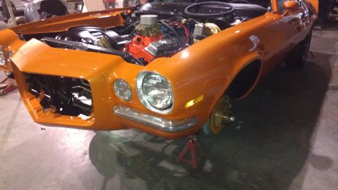 1973 Chevrolet Camaro - This orange 1973 Chevrolet Camaro is shown in a 3/4 front view with its engine exposed and the vehicle on jack stands.