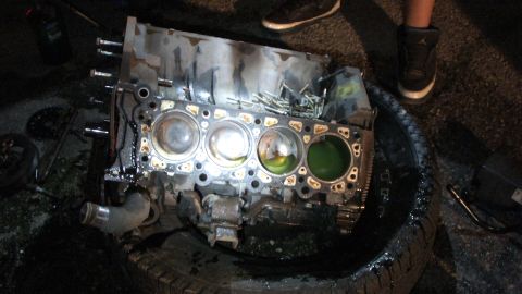2003 Ford Crown Victoria - Top-down view of a stripped block on a tire showing open bores and a green-coolant cylinder