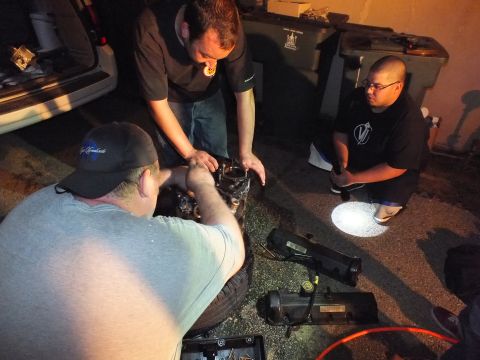 2003 Ford Crown Victoria - Men inspect engine components on the ground, one in a ball cap lit by a flashlight