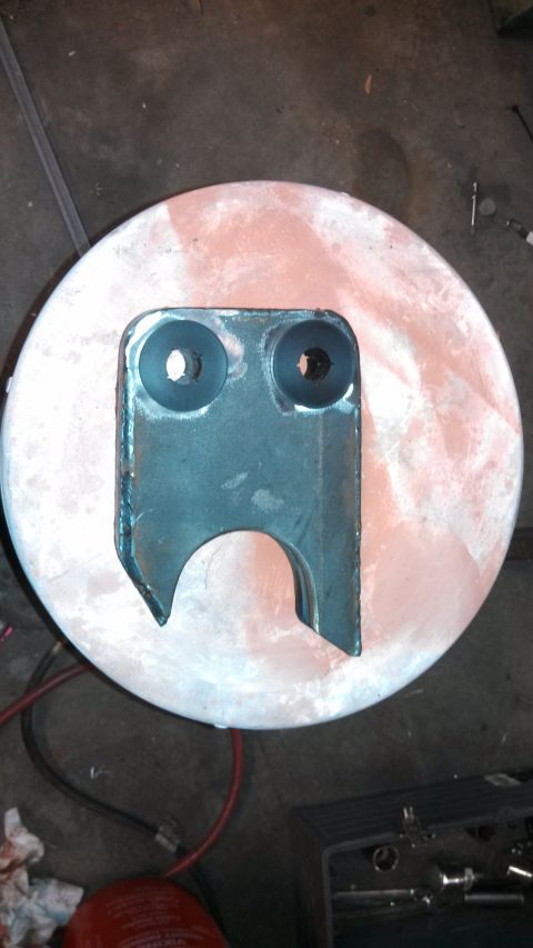 1967 Ford F-250 - A fabricated metal bracket with two circular holes and a U-shaped cutout is shown.