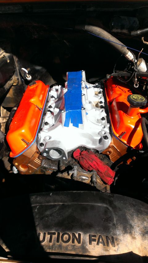 1990 Ford Bronco - Close-up of an engine's intake manifold and valve covers during a build or repair.