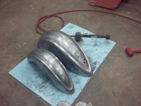 1995 Ford F-150 - Two unpainted metal fenders are laid out on a blue mat, ready for installation or further work.