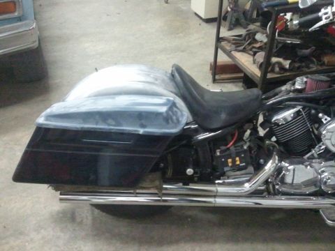 1995 Ford F-150 - A motorcycle is parked indoors, showing its side profile with saddlebags and exhaust.