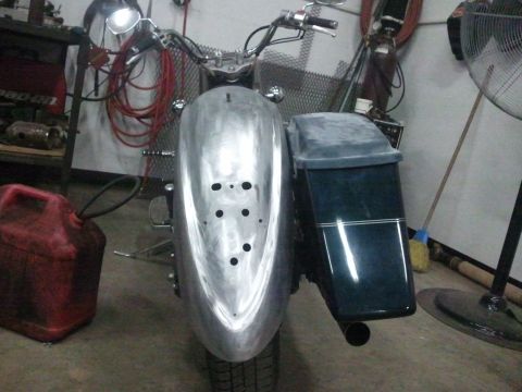 1995 Ford F-150 - A motorcycle is shown from the front, a bare metal fender with multiple drilled holes and a dark saddlebag on the right side.