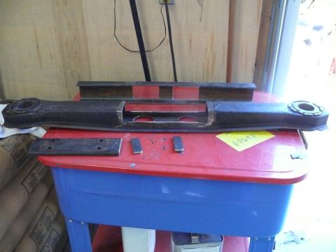 1976 Chevrolet Corvette - A car part is laid out on a red and blue table, with other metal pieces nearby.