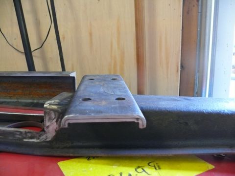 1976 Chevrolet Corvette - Metal bracket with bolt holes, likely a vehicle part, held in a vise.