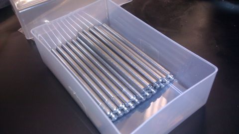 1996 Ford Bronco - A clear plastic box holds a set of identical metal rods, neatly arranged.
