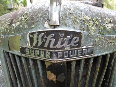 1991 Ford Bronco - Close-up of a White Super Power emblem on an old vehicle's front grille.