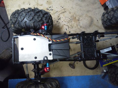 1985 Ford Bronco - The underside of a remote control car chassis is shown, revealing its mechanical components and suspension.