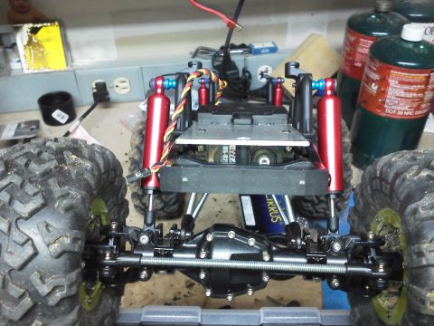 1985 Ford Bronco - Close-up of a remote control car chassis, showing suspension and drivetrain components.