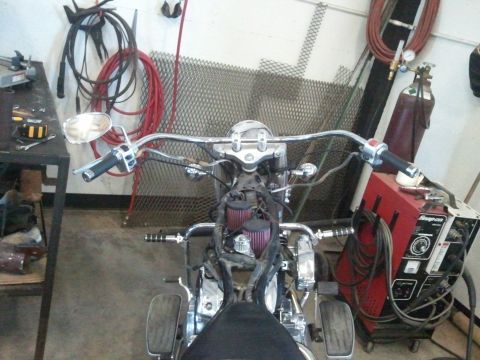 1995 Ford F-150 - A motorcycle is parked in a workshop with tools and equipment in the background.
