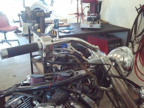 1995 Ford F-150 - Close-up view of motorcycle handlebars and engine components, possibly undergoing maintenance or customization in a workshop environment.