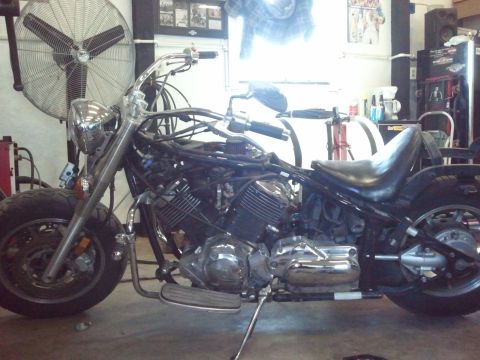 1995 Ford F-150 - A motorcycle is parked in a garage with a large fan in the background.