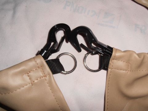 1990 Ford Bronco - Close-up of tan fabric straps with black plastic clips and metal rings.