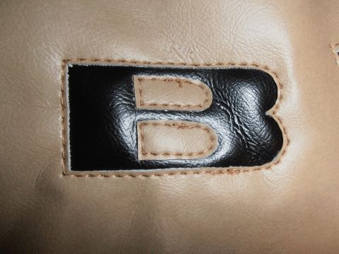 1990 Ford Bronco - Close-up of a stitched letter B applique on a tan background.