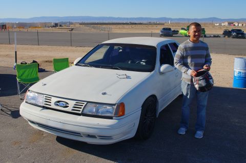 1995 Ford Taurus - A white sedan with racing modifications is parked on a track.