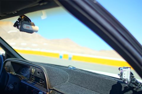 1995 Ford Taurus - Interior view of a vehicle with a dashcam and mount, overlooking a bright yellow and blue track.