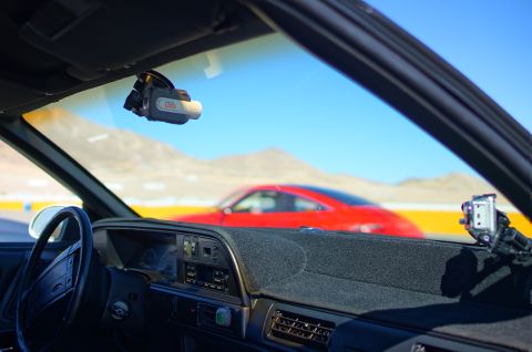 1995 Ford Taurus - Dash view from inside a car, with a red car visible through the windshield and two cameras mounted.