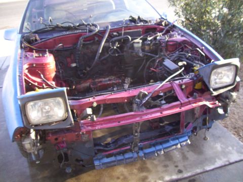 1995 Ford Probe - Front end of a 1995 Ford Probe disassembled, revealing the engine bay and wiring.