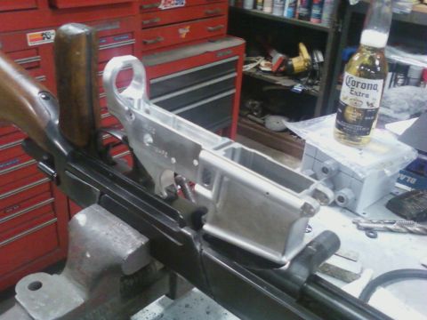1978 Ford F-250 - A gun receiver is being worked on in a workshop, with tools and a beer bottle nearby.