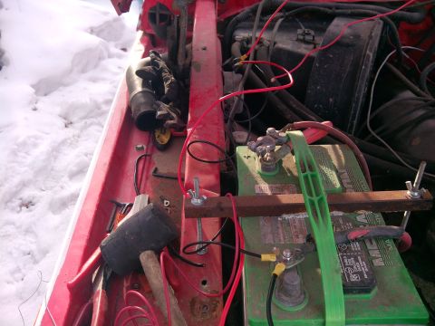 1979 Ford Bronco - Close-up view of a vehicle's engine bay, showing the battery, wiring, and various tools.