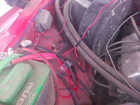 1979 Ford Bronco - Close-up of engine bay wiring and battery terminals, showing various electrical components and connections.