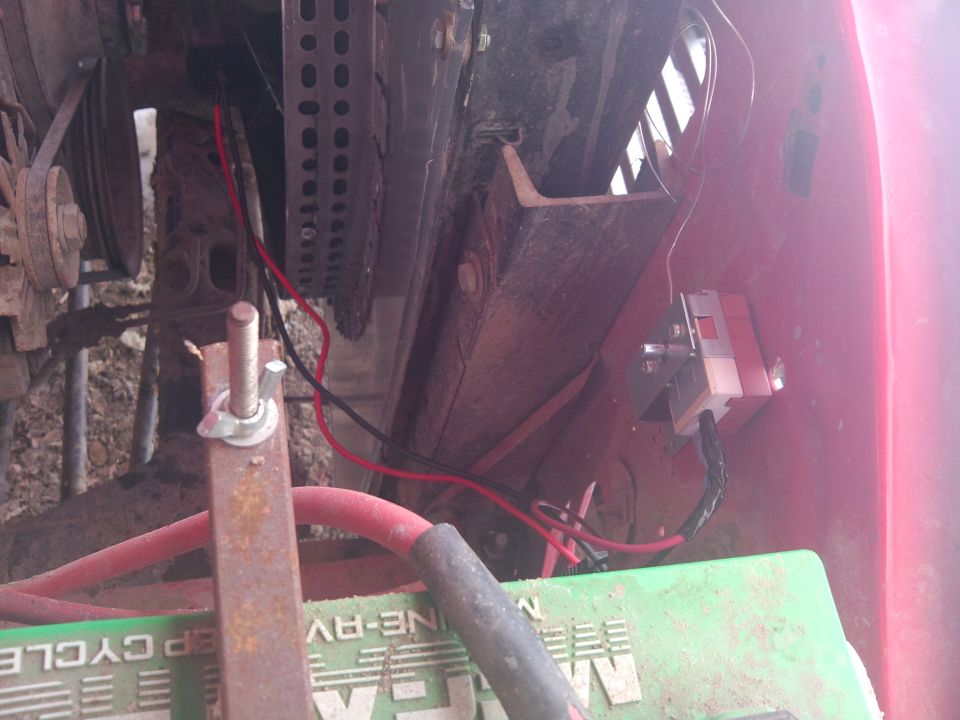 Close-up of engine bay wiring, battery, and some metal brackets
