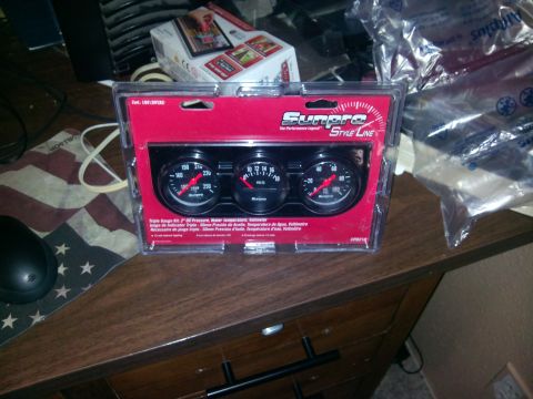 1979 Ford Bronco - A Sunpro Style Line triple gauge kit is packaged for sale, displaying oil pressure, voltage, and water temperature readings.