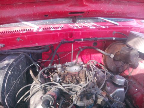1979 Ford Bronco - Close-up view of a vehicle's engine bay, showing the carburetor, brake booster, and air filter assembly.
