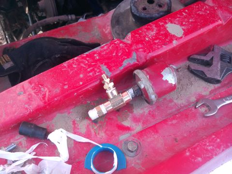 1979 Ford Bronco - Tools and parts are laid out on a red surface, possibly in an engine bay.