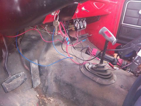 1979 Ford Bronco - The interior of a vehicle displays exposed wiring and a set of keys in the ignition.
