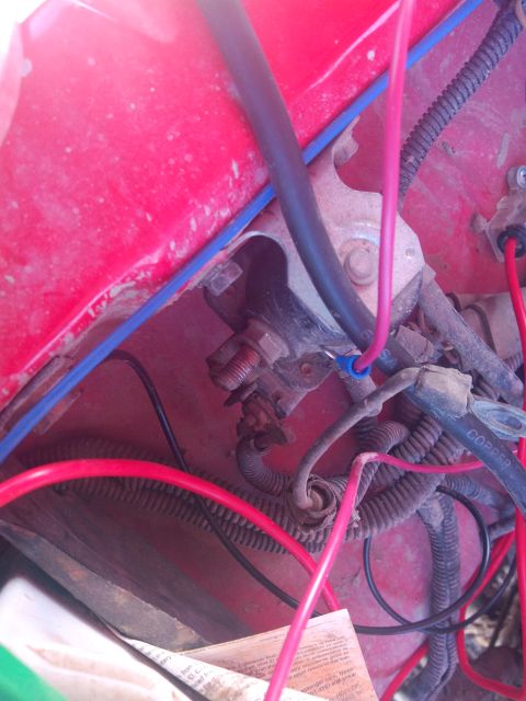 1979 Ford Bronco - Detail of wiring and electrical components within a red engine bay.