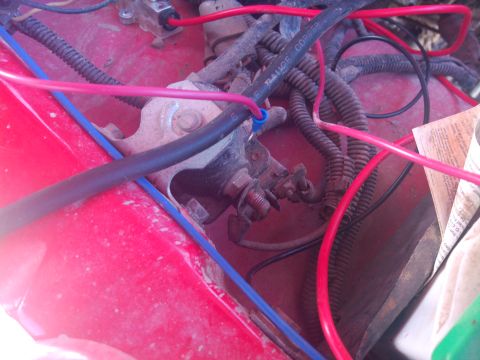 1979 Ford Bronco - Engine bay wiring harness with multiple red and blue wires and protective tubing.
