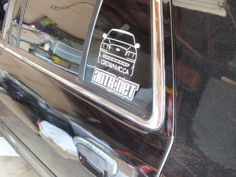 2003 Ford Crown Victoria - Angled shot of white CrownVic.ca outline and ADTR.net logo decals on the rear side window of a glossy black sedan