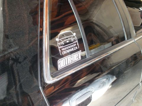 2003 Ford Crown Victoria - White vinyl CrownVic.ca and ADTR.net stickers applied to the heavily tinted rear quarter window of a black car